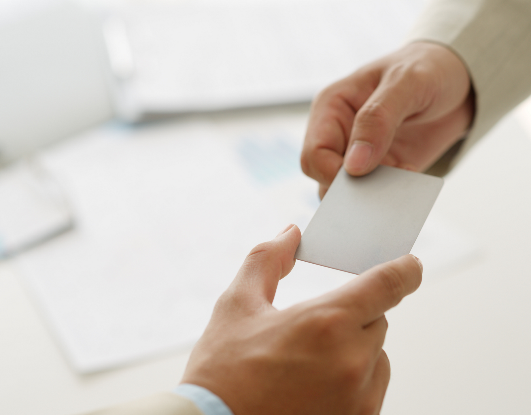 Man handing blank card to another person